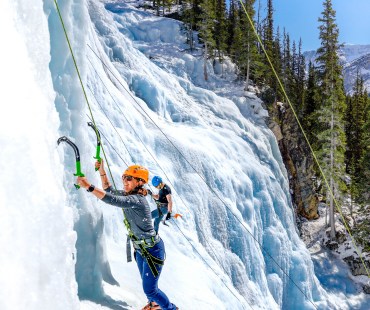 Person climbing up the Frozen ice at Tangle Falls