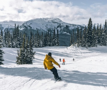 Snowboarder cruising down run at Whistler Blackcomb