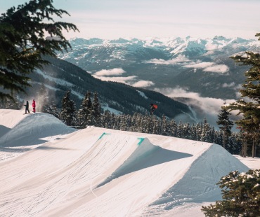 Snowboarder hitting a large jump at Whistler