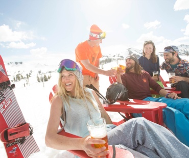 People relaxing on the snow beach enjoying a drink