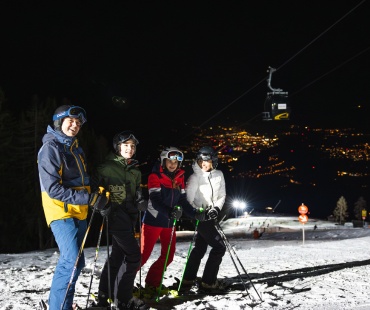 people on the slopes with city lights in the background