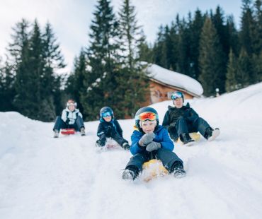 Kids enjoying sledding down the snowy trails