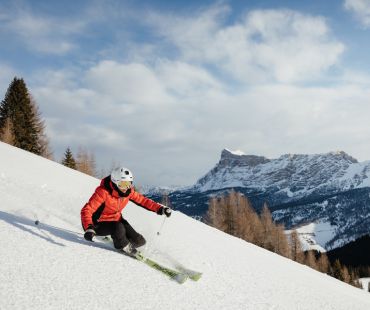 Skier carving through snow covered back country