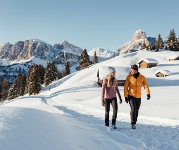 Two people enjoying a walk through the snow Dolomites