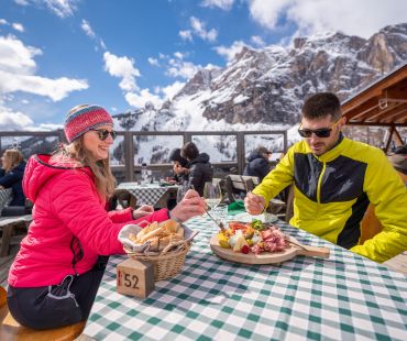 People enjoying wine and cheeseboards with mountain views