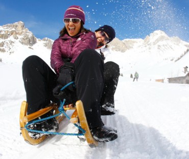 People racing down trails on sled