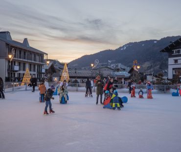 Adults and children enjoying skating on the ice rink