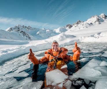 Person in full scuba gear taking a dive in the icey water