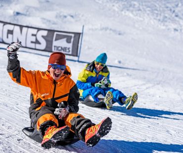 Kids racing sleds down the trails