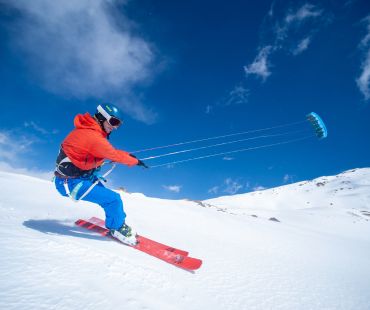 Person catching wind with sails on skis