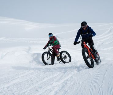 Pair of people fat biking on deep snowy trails