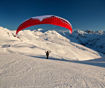 Person parachuting high up in the Alps