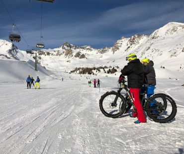 People on fatbikes watching skiers on trails