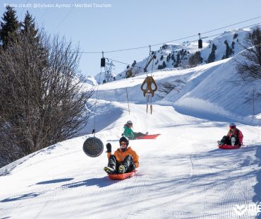 People sledding down trails at Meribel