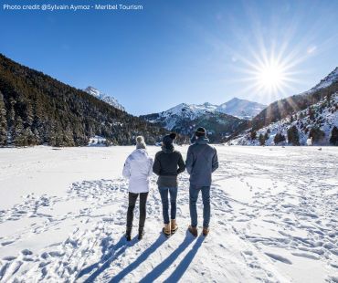 Three people walking in the snowy terrain