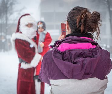 Person taking picture of child with Santa