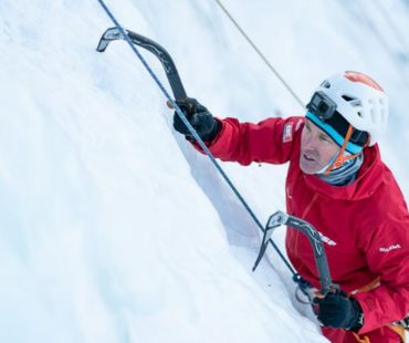 Man climbing up frozen waterfall