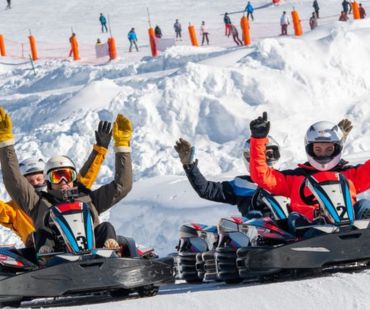 People racing go karts on the snow