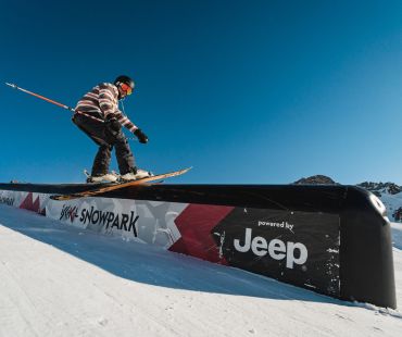 Skier hitting rail at snow park