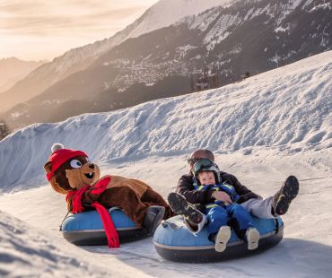 People and mascot tubing on snow trails