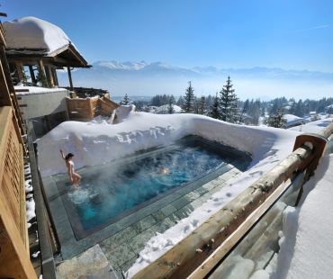 People in snow surrounded thermal pool