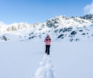 Person wearing snowshoes hiking through deep snow