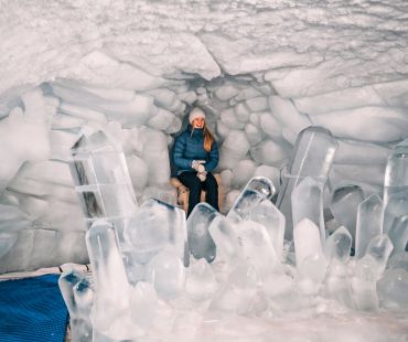 Person sitting on ice throne inside cave